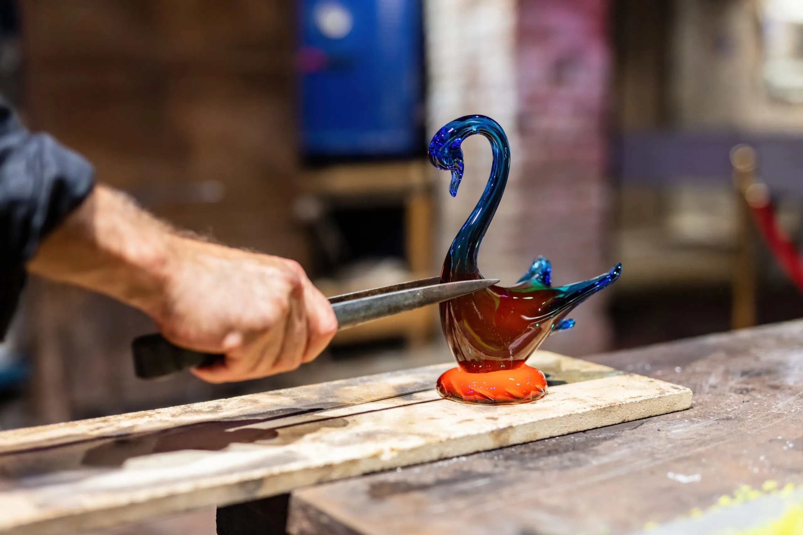 Glass blower at work in workshop in Murano, Italy, making handmade glassware