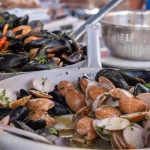 Cooked mussels and seafood in pan, food market Ballaro in Palermo, Sicily