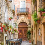 Cafe tables and chairs outside in old cozy street in the Positano town, Italy
