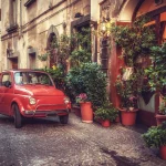 Old vintage cult car parked on the street by the restaurant, in