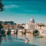 Rome, Italy. Papal Basilica Of St. Peter In The Vatican. Sightseeing Boat Floating Near Aelian Bridge. Tour Touristic Boat